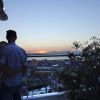 Coppia abbracciata osserva il tramonto su una terrazza.