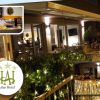 Un ristorante esterno con piante e luci.