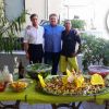 Tre persone davanti a un buffet all'aperto.