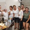Otto persone in una cucina, sorridenti.