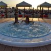 Due persone in una vasca idromassaggio al tramonto.