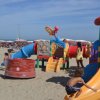 Parco giochi colorato su spiaggia sabbiosa.