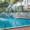 Piscina con fontana, circondata da alberi e un edificio moderno.