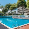 Piscina blu circondata da alberi e palazzi.