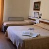Camera con letto matrimoniale e letto singolo, tende arancioni.