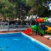 Piscina con scivolo colorato nelle vicinanze di alberi.