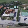 Veduta aerea di un complesso turistico con campi sportivi e parcheggio.