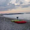 Spiaggia con canoe colorate al tramonto.