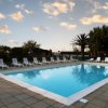 Piscina all'aperto con lettini intorno al bordo.