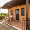 Veranda esterna con sedie e tavolo sotto una tettoia.
