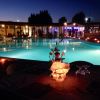 Piscina illuminata di sera con decorazione floreale sui tavoli.