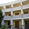 Edificio residenziale con balconi e persiane marroni.