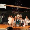 Persone in abiti festivi, coriandoli sul palco.