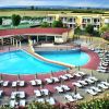 Ampia piscina circondata da lettini e ombrelloni.