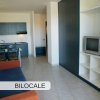 Soggiorno con cucina, divano e TV.