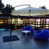Sedie a sacco viola e ombrellone su terrazza.