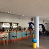 Bancone bar con sedie e decorazioni murali stilizzate.