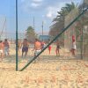 Persone giocano a pallavolo sulla spiaggia.