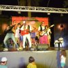 Persone su un palco, suonano chitarre.