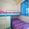Letto a castello con coperte colorate e tenda blu.