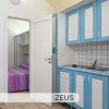 Cucina bianca e blu con lavello e porta aperta verso la camera da letto.