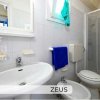 Bagno con lavandino, bidet e doccia, asciugamano blu appeso.