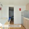 Cucina moderna con tavolo bianco e sedie.