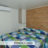 Camera da letto con parete in legno e copriletto colorato.
