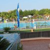 Una piscina con scivolo e lettini attorno.