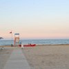 Spiaggia con lettini e ombrelloni a riva.