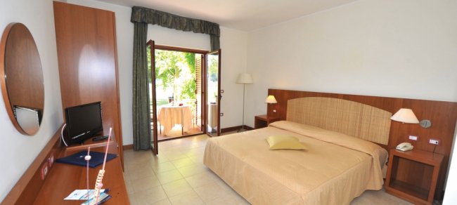 Camera da letto con letto matrimoniale e porta-finestra.