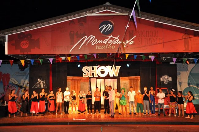 Persone in piedi su un palco all'aperto decorato.