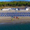 Spiaggia con ombrelloni blu vicino a un edificio bianco.