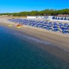 Ombrelloni blu sulla spiaggia, vicino al mare azzurro.