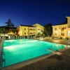 Piscina illuminata di notte con sedie a sdraio.