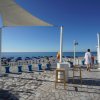 Terrazza vista mare con ombrelloni blu.