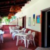 Veranda coperta con sedie e tavoli bianchi.