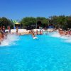 Piscina affollata con persone che schizzano acqua.