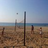 Tre persone giocano a pallavolo sulla spiaggia.