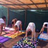 Persone fanno yoga sotto un pergolato.