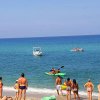Persone in spiaggia e kayak in mare.