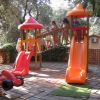 Bambini giocano su scivoli arancioni in un parco giochi.