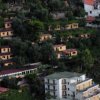 Complesso di edifici su pendio collinare immersi nel verde.