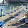 Spiaggia con lettini e ombrelloni gialli e blu.