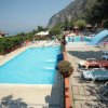 Piscina all'aperto con sdraio e scivolo blu.