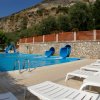 Piscina con scivoli blu e sdraio bianche.