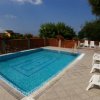 Piccola piscina circondata da sdraio bianche.