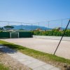 Campo da calcetto con rete di recinzione e montagne sullo sfondo.