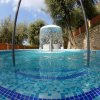 Piscina con cascata e sedili piastrellati.