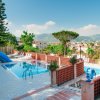 Piscina con scivolo blu e lettini.